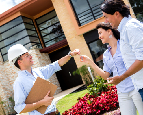 architect handling keys to a couple